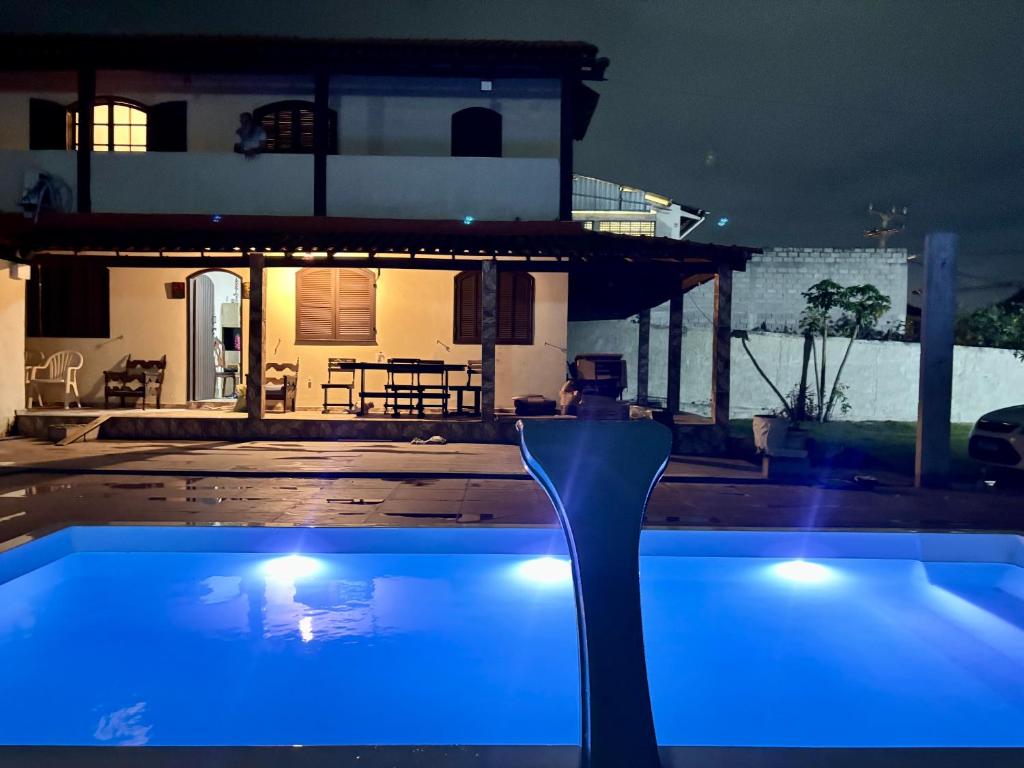 a swimming pool at night with a house in the background at Casa Colonial Recanto da Família & Amigos e Kit Anexa! in São Pedro da Aldeia