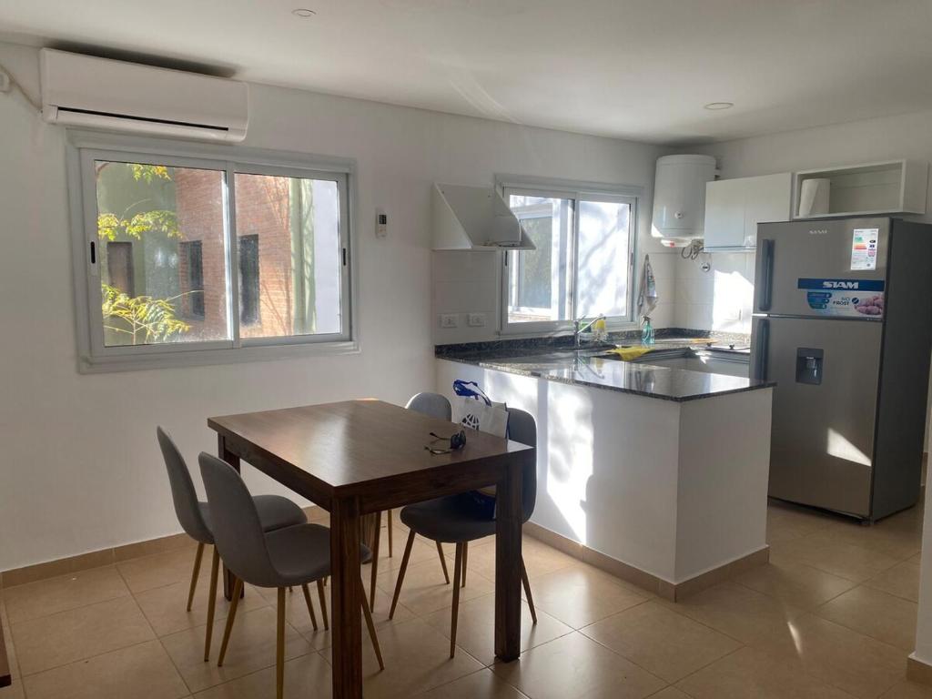 a kitchen with a wooden table and a table and chairs at Departamento Soles in Posadas