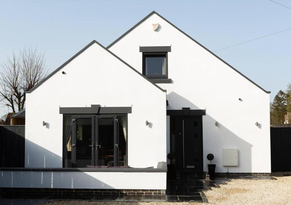 a white house with black doors and a fence at 2 Bed House with Hot Tub Great Ayton - TOP House in Great Ayton