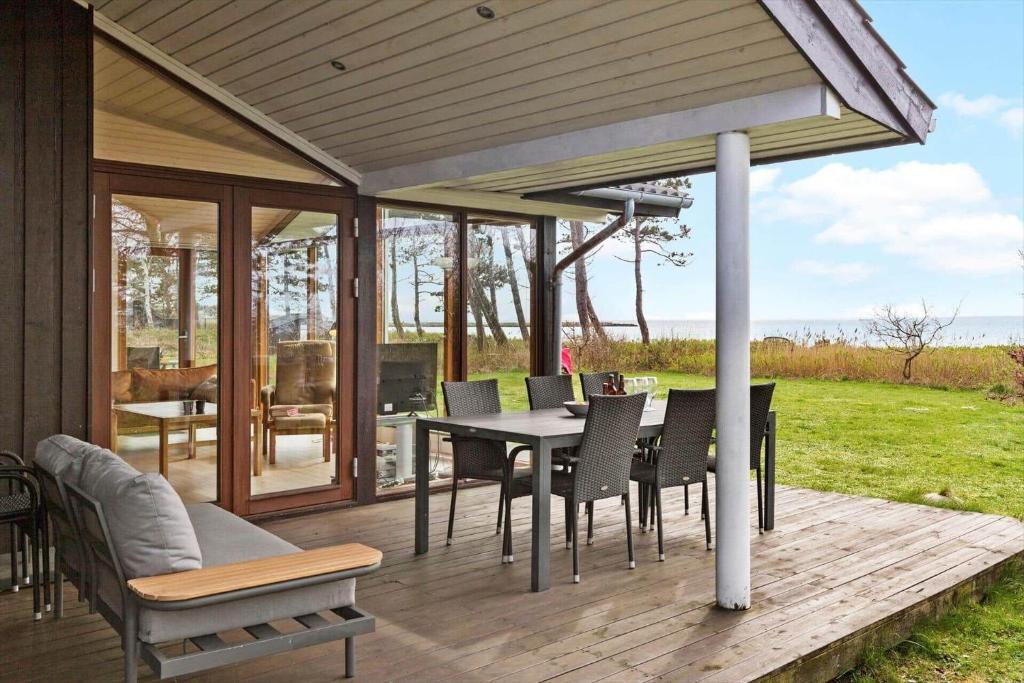 eine Terrasse mit Tisch und Stühlen auf einem Deck in der Unterkunft 8451 Knebel - Fyrrevej 9 in Knebel