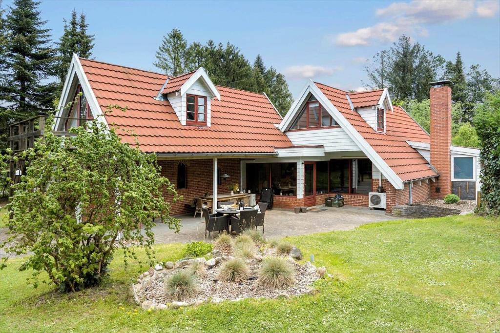 une maison avec un toit orange et une cour dans l'établissement 84109-8400-Birkevej-1, à Øksenmølle