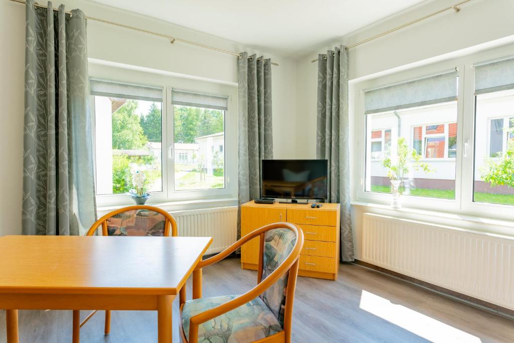 a dining room with a table and a television at Jugendbegegnungsstätte Am Kutzow-See Plöwen in Plöwen