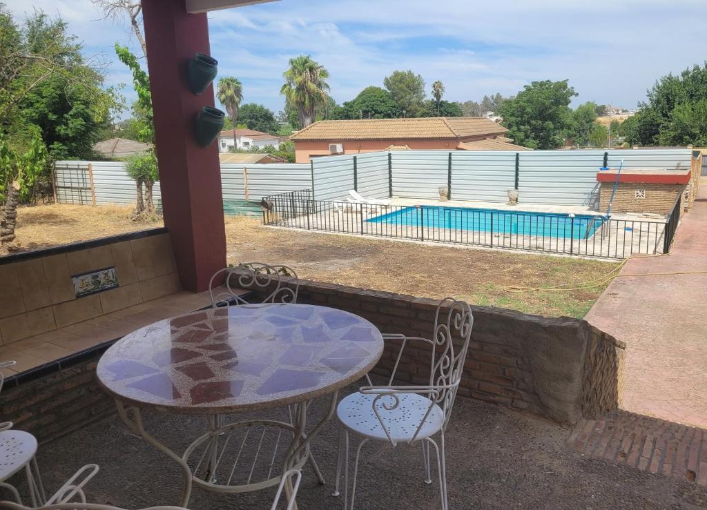 Un patio con mesa y sillas y una piscina. en Villa Manolita, en Torrepalma