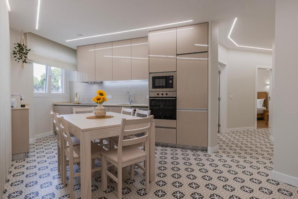 a kitchen with a table and chairs and a kitchen with appliances at Modern 2BR Apt with Patio and AC in Lisbon