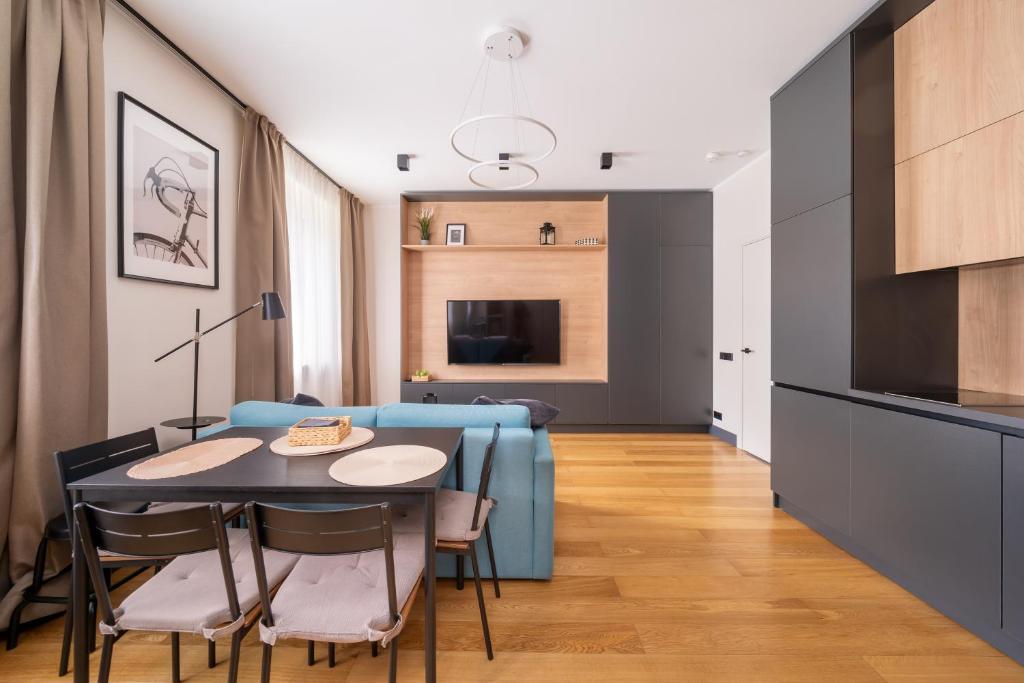 a living room with a table and a blue couch at Premium One Bedroom Apartment Dzintari Beach & Park in Jūrmala