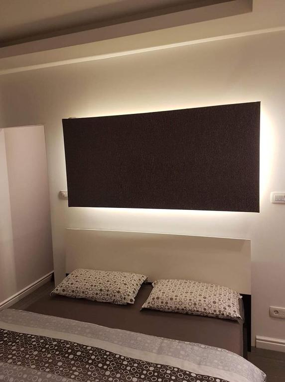 a bed with two pillows in a room at Calma house in Podgorica