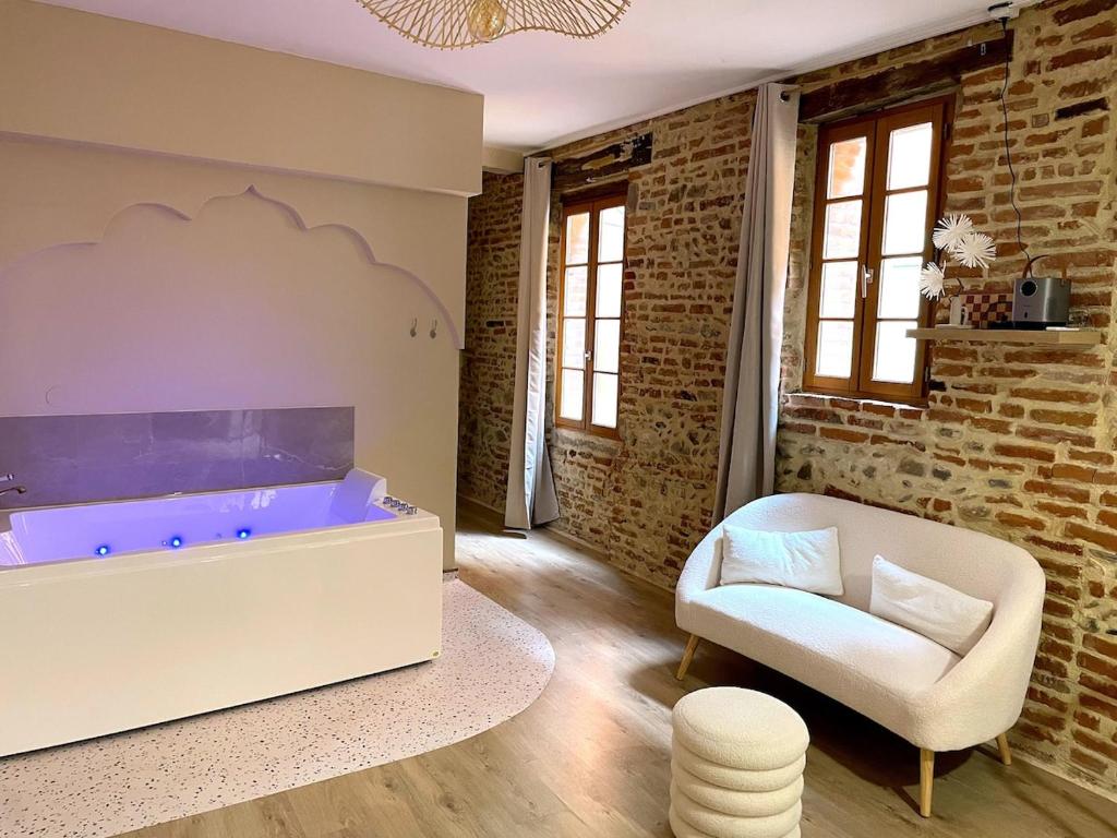 a living room with a tub and a chair at Les 1001 nuits in Albi