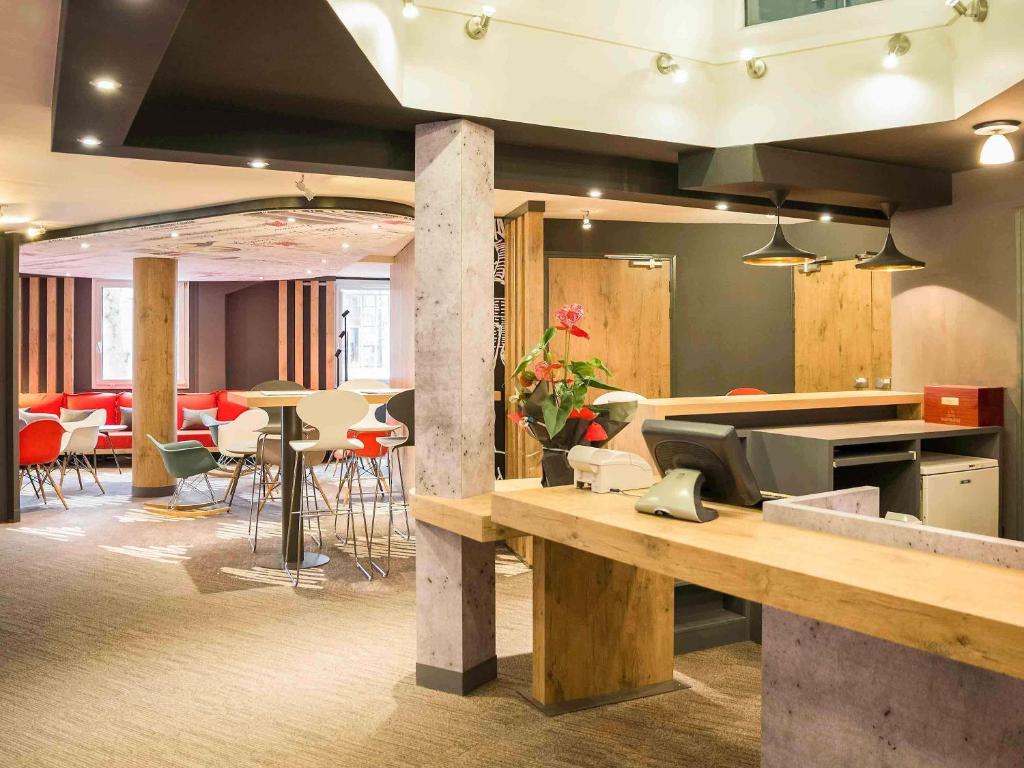 a large room with tables and chairs in a building at ibis Paris Brancion Parc des Expositions 15ème in Paris