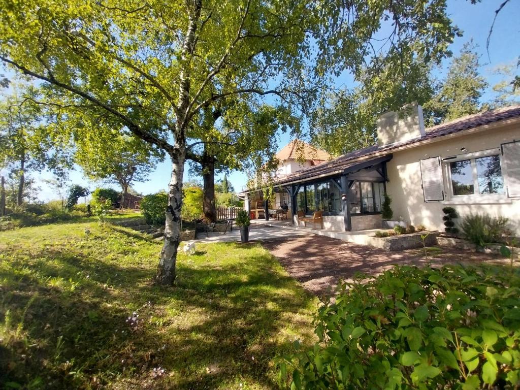 a house with a tree in the yard at La Chesnaie in Bonnes