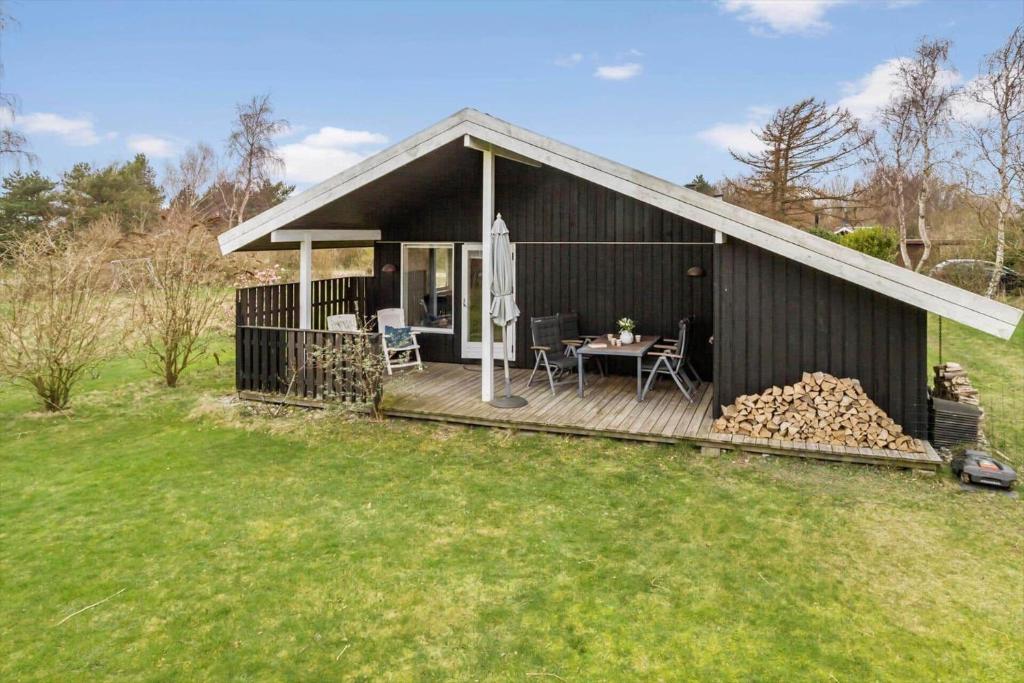 a house with a deck with a table on it at 20125-Samso-Spaetmejsevej-2 in Nordby