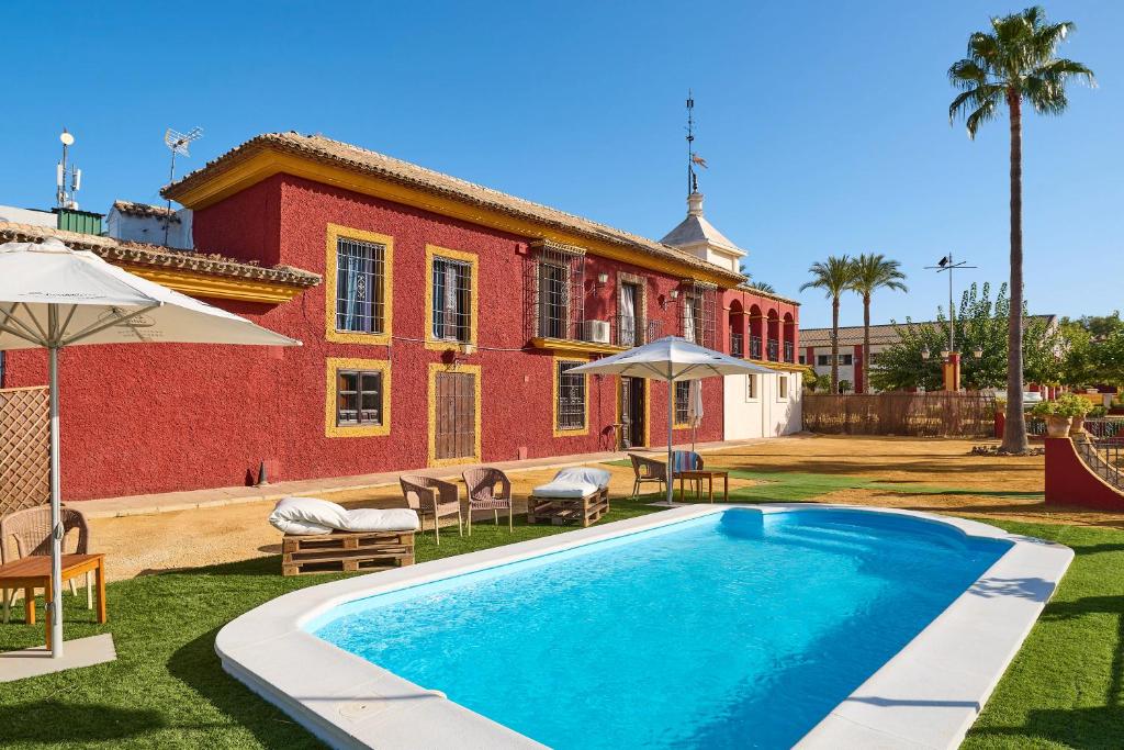 a swimming pool in front of a house at Holiday House Dehesa del Colmenar in Cabra