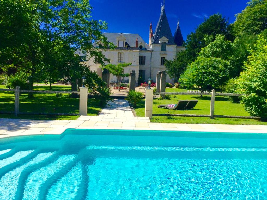 a blue swimming pool in front of a house at Château De La Coutancière in Brain-sur-Allonnes