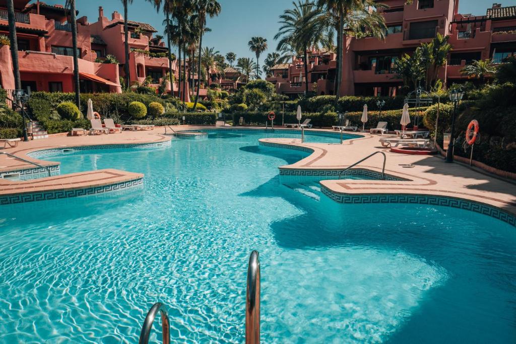una piscina con agua azul en un resort en Luxury Sea View Oasis EHHouse, en Estepona