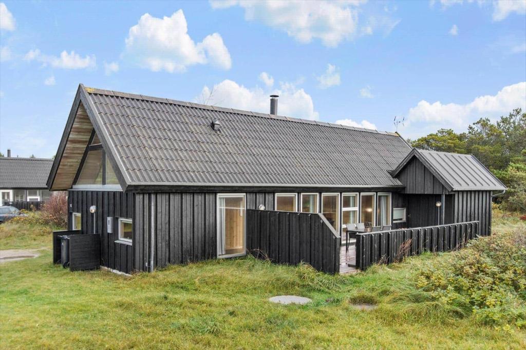 a black house with a fence in front of it at TV1658-Skagen-Klyngen-10 in Skagen