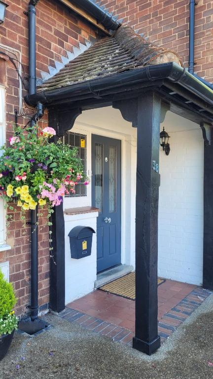 an entrance to a brick house with a blue door at Hampton Lodge En-Suite Rooms with Free Parking in Stratford-upon-Avon