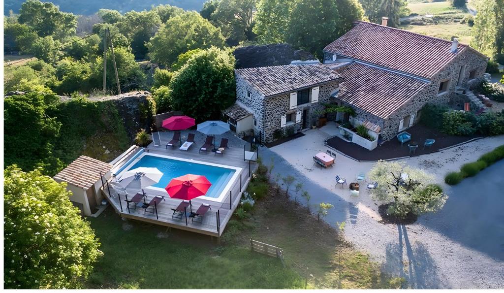 an aerial view of a house with a swimming pool with umbrellas at La Ferme De Mon Grand-père in Saint-Pons