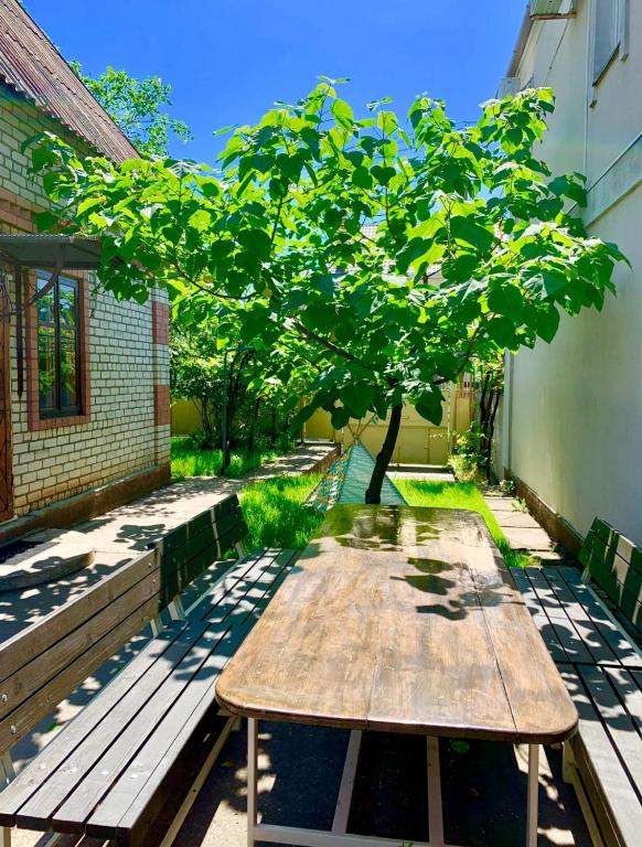a wooden table sitting on the side of a building with a tree at Amore in Zatoka