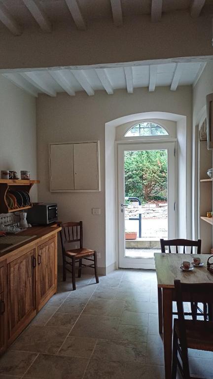 a kitchen with a table and a large window at Il Sensalino in San Donato in Poggio