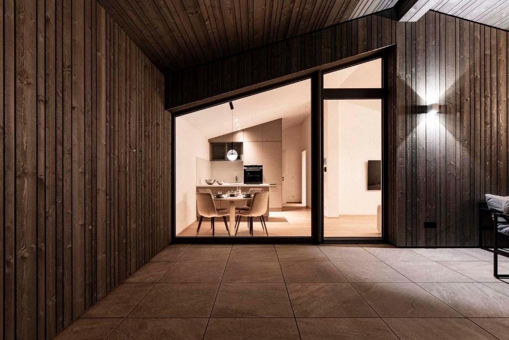 a dining room with sliding glass doors and a table at 21trees in Ellmau