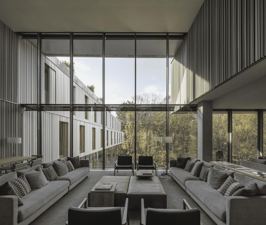 a large room with couches and tables and large windows at Hotel Arima &amp; Spa - Small Luxury Hotels in Donostia-San Sebastián