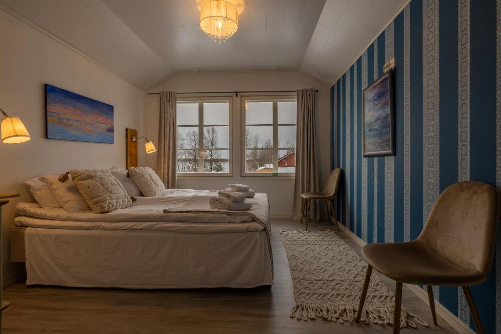 a bedroom with a bed and a window and a chair at Loimu Resort in Ylläsjärvi
