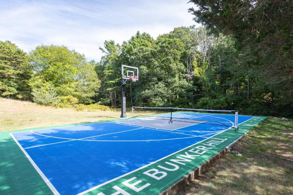 a tennis court with a basketball hoop on it at Stay On The Cape Vacation Rentals: Immaculate Home 2 Acres Short Walk To Beach in Bourne