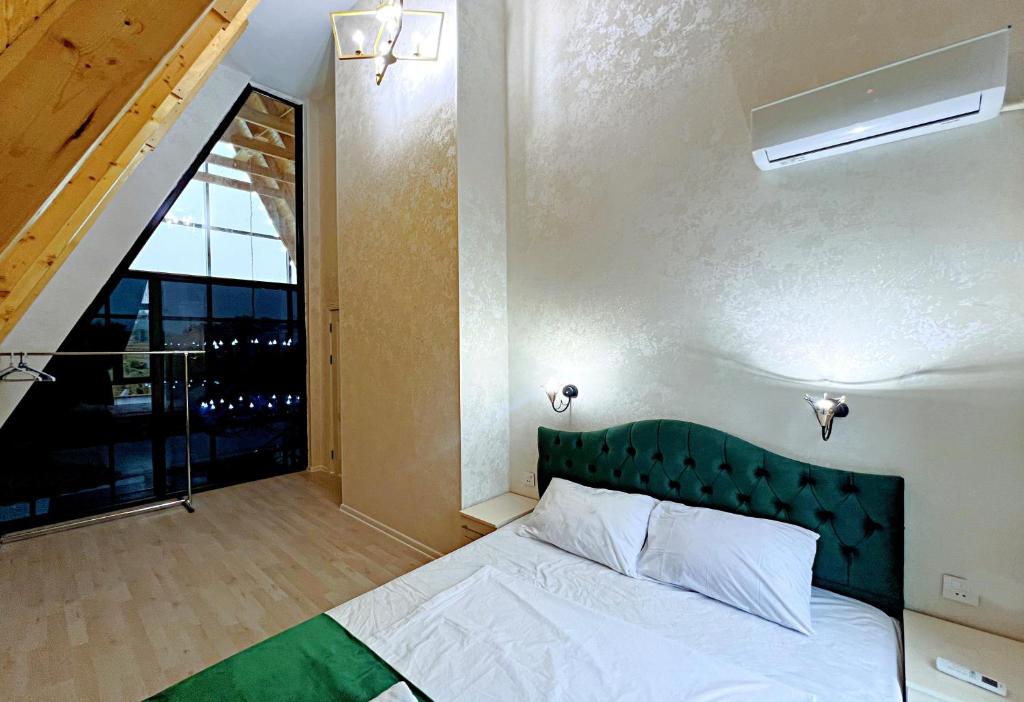Un dormitorio con una cama y una ventana grande. en ES A frame, en Gabala