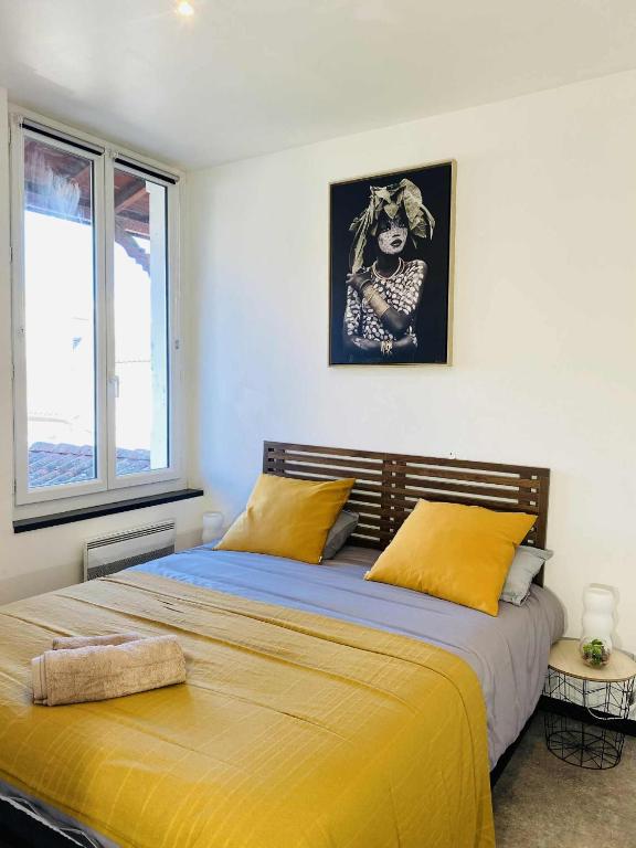 a bedroom with a large bed with yellow sheets at L'escale Urbaine avec fibre internet 4 pers Confort & Emplacement Idéal in Marmande