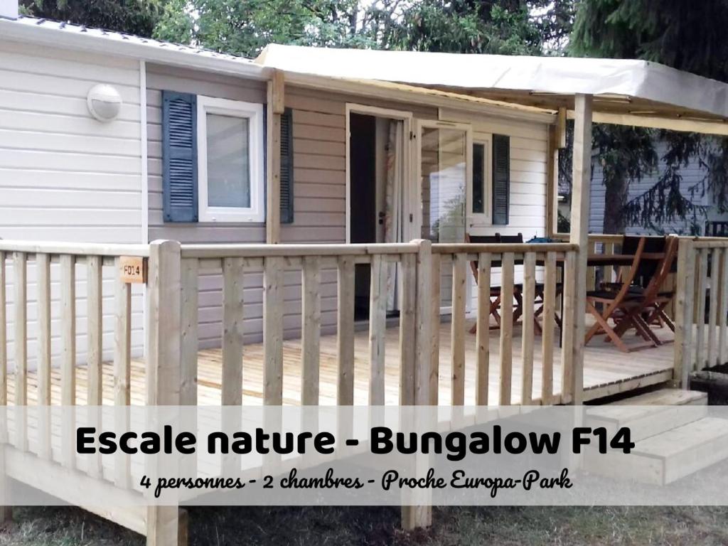 a tiny house with a porch and a deck at Escale Nature - Bungalow F14 pour 4 au camping Le Ried in Boofzheim