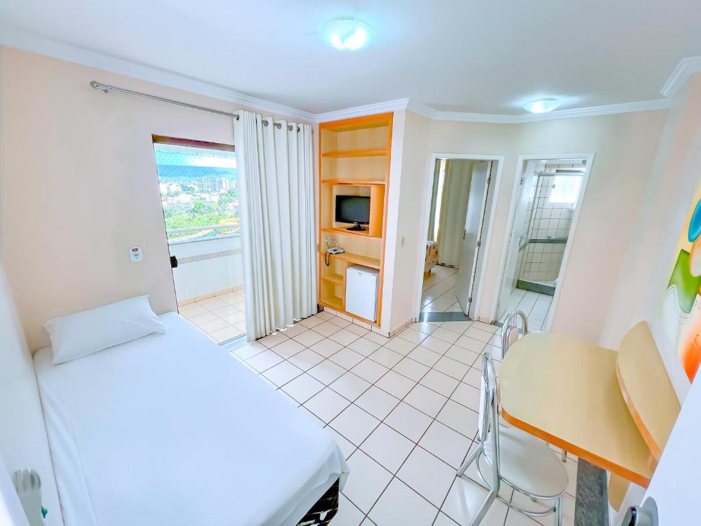 卡达斯诺瓦斯diRoma Villas direto com o Grupo diRoma com acesso ao Acqua Park e Café da manhã的一间卧室，配有一张床、一张书桌和一张桌子