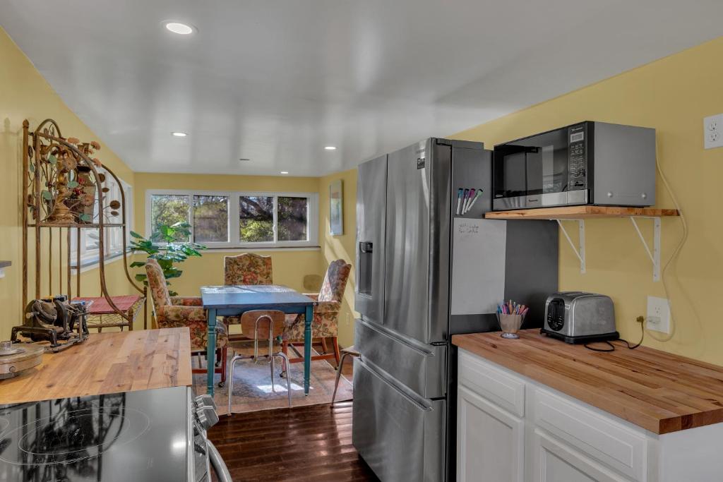 a kitchen with a stainless steel refrigerator and a table at The Whiskey River Lodge in Madison