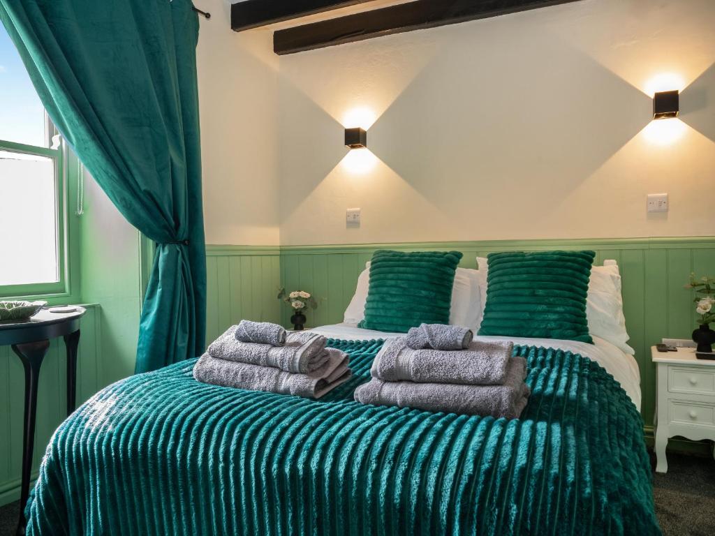 ein Schlafzimmer mit zwei Betten mit Handtüchern darauf in der Unterkunft Heart Stone Cottage in Staithes