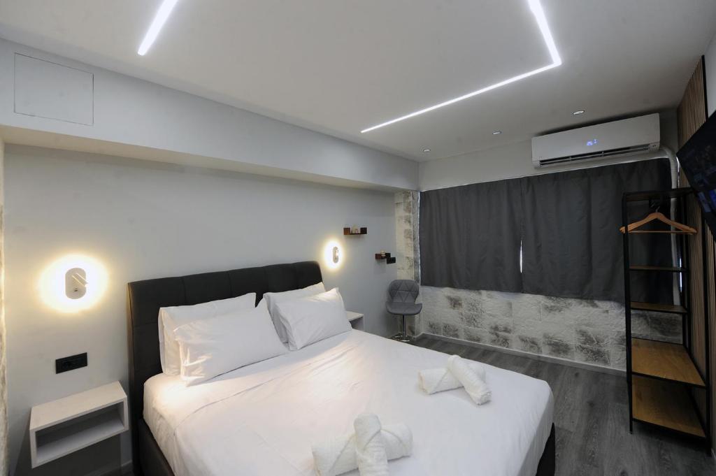 ein Schlafzimmer mit einem großen weißen Bett mit weißen Kissen in der Unterkunft Cozy Loft Monastiraki in Athen