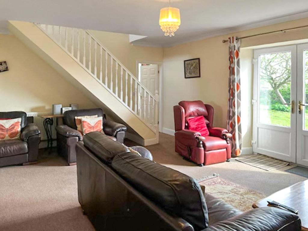 a living room with a couch and chairs and stairs at Middle Farm in Durham