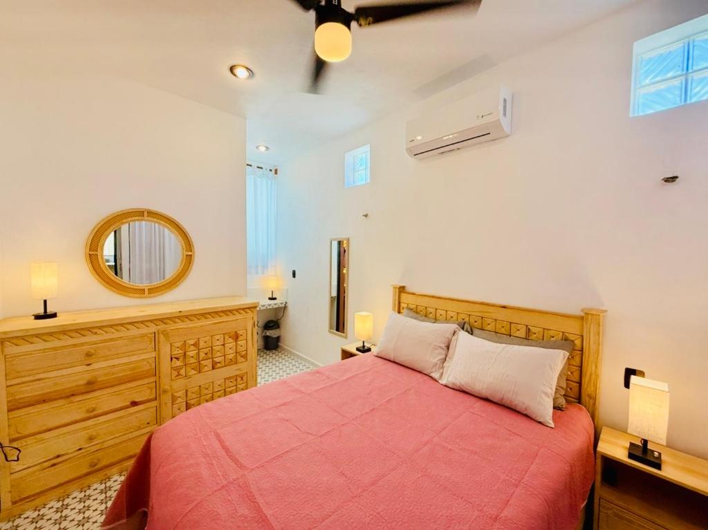 a bedroom with a red bed and a mirror at CASA DE PLAYA con PISCINA en SISAL SÚPER EQUIPADA in Sisal