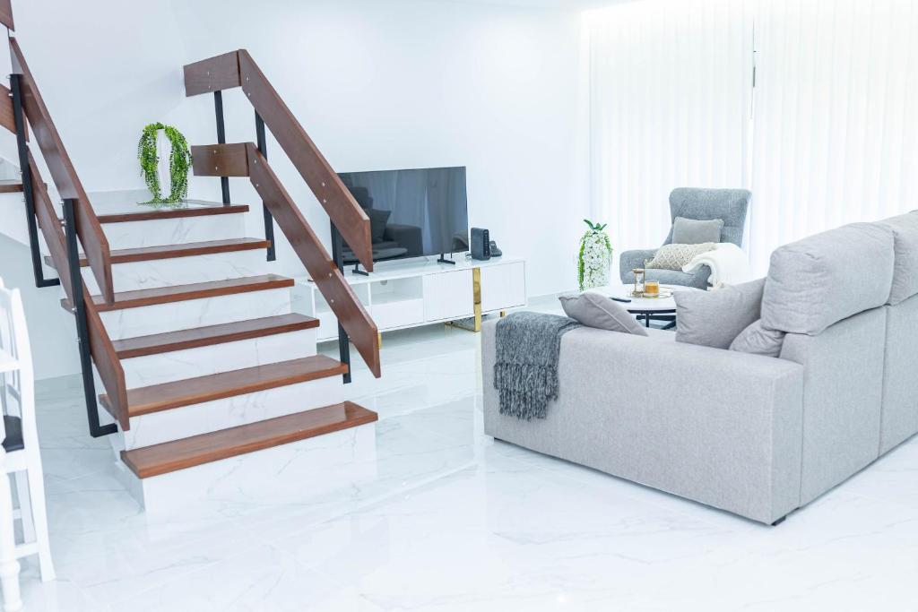 a living room with a couch and a staircase at MCM Matur Flats 2, 11 Duplex in Santa Cruz