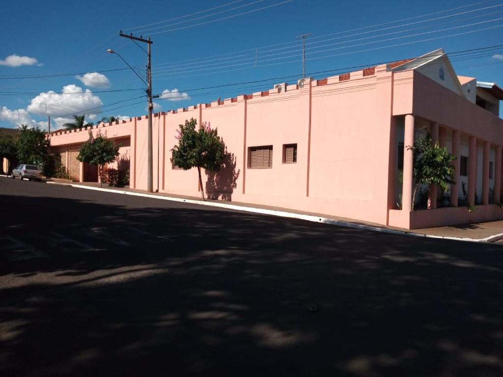 a large pink building on the side of a street at Pousada Am confort turiuba ltda in Turiúba