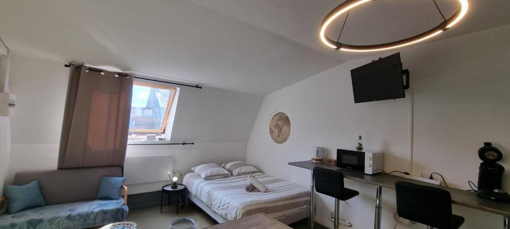 une petite pièce avec un lit et un canapé dans l'établissement T1 rénové 26m2 cosy confort !, à Anzin