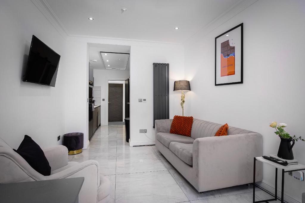 a white living room with a couch and a tv at Edinburgh City 2Bedroom & steam room! in Edinburgh