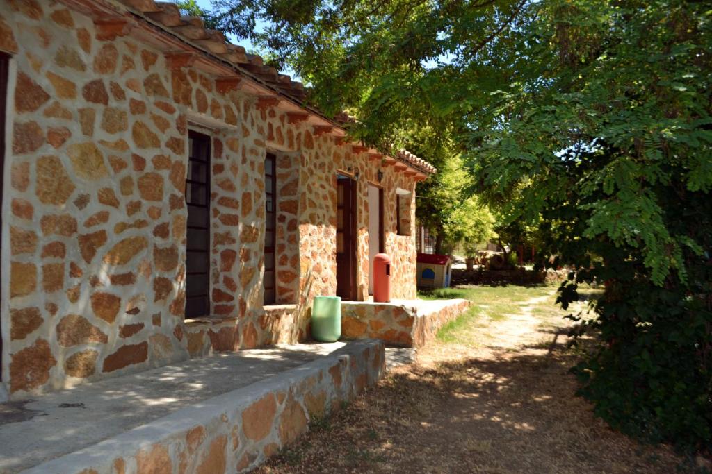 a stone building with a tree next to it at La Casa de la Montaña in Cortes de Arenoso