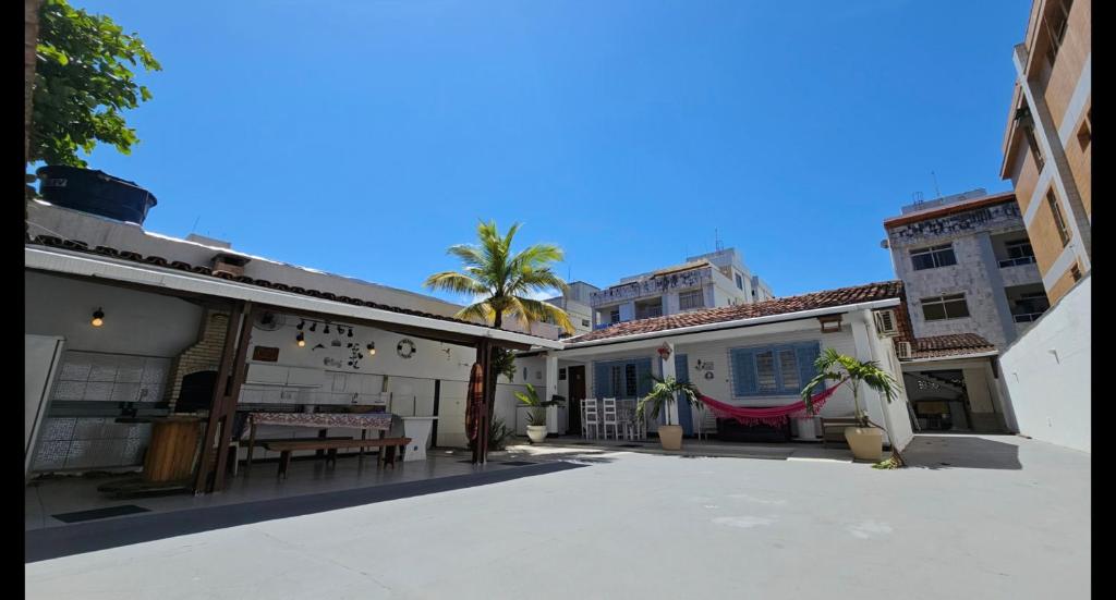 a courtyard of a building with a palm tree at Casa de aluguel temporada em Guarapari 7 quartos in Guarapari