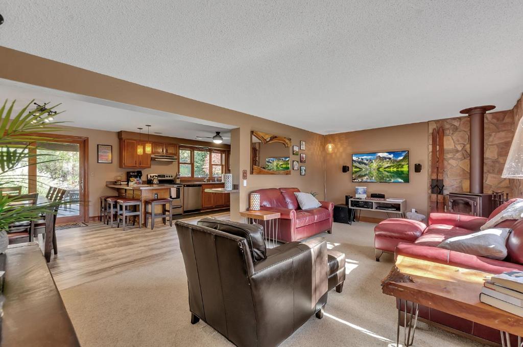 a living room with red furniture and a kitchen at EVL Après4All: game rm,hot tub,steps 2 town&trails in Ellicottville