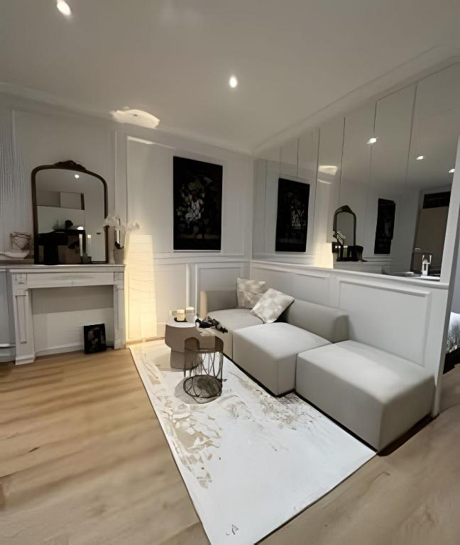 ein Wohnzimmer mit einer weißen Couch und einer Küche in der Unterkunft Charming Apartment in Saint-Gilles, Brussels, Perfect Getaway in Brüssel