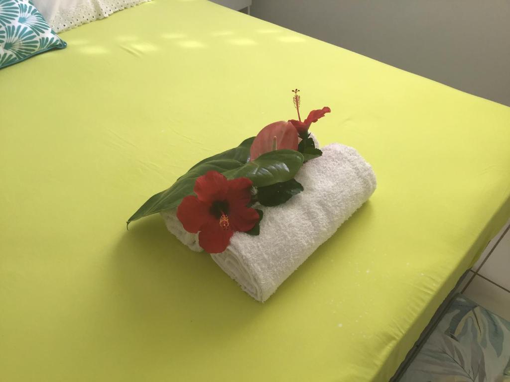a flower on top of a towel on a table at Villa du coeur in Deshaies