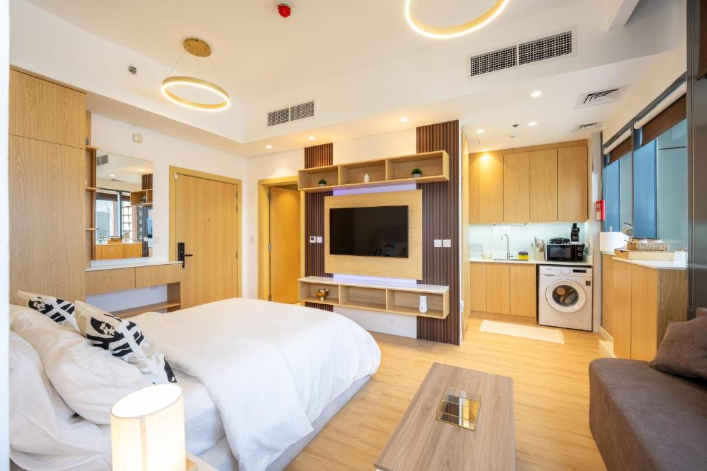 a bedroom with a bed and a living room at Luxury Studio JVC Open View in Dubai
