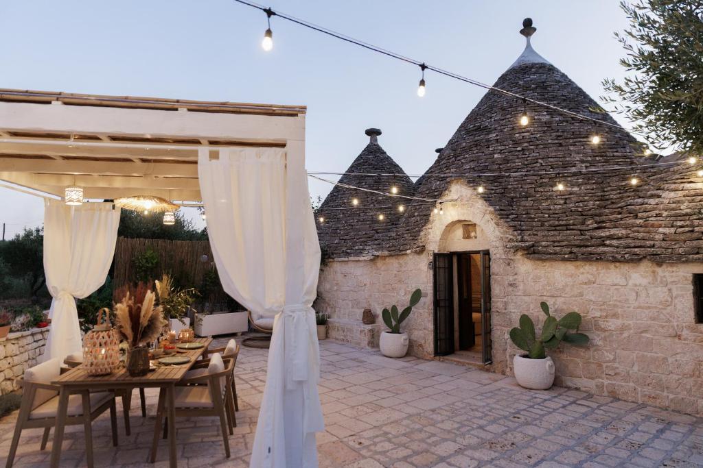 an outdoor patio with a table and curtains at Trulli Arborea in Alberobello