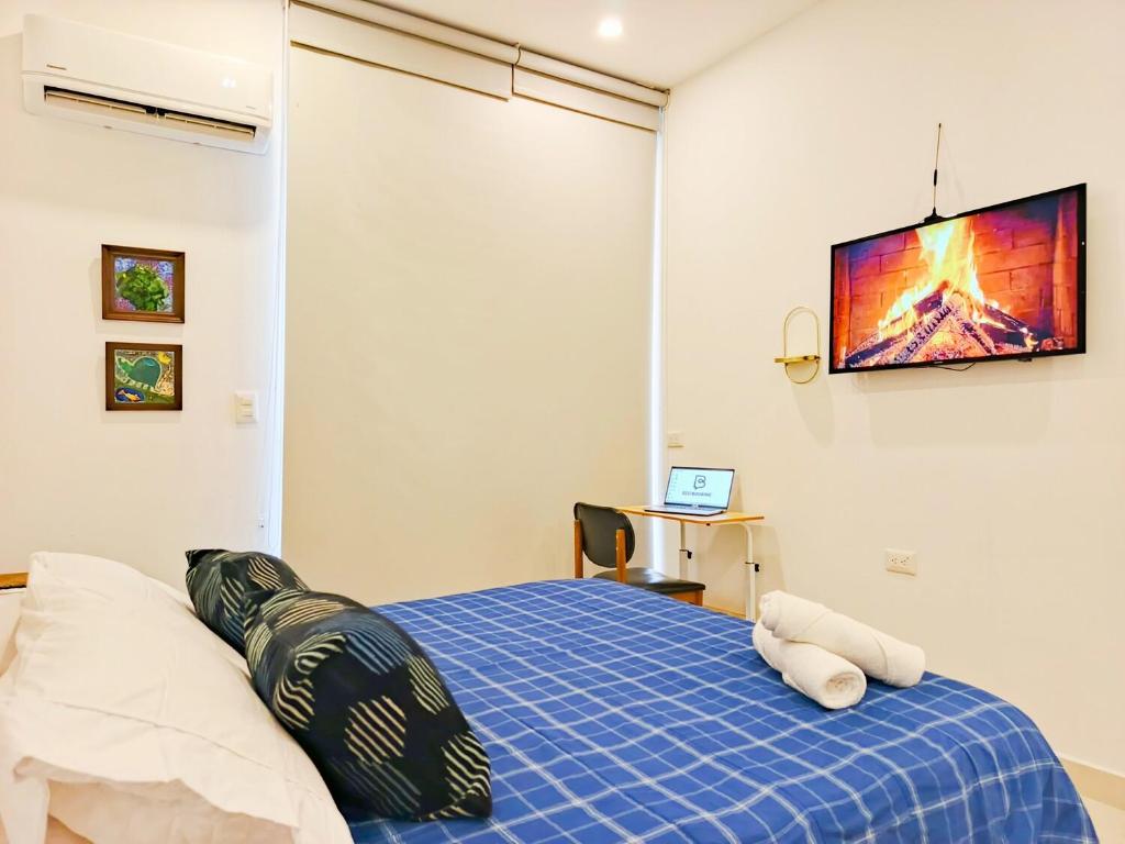 a bedroom with a bed and a tv on the wall at Habitación Suite Cerca al Mar - Santa Marta in Santa Marta