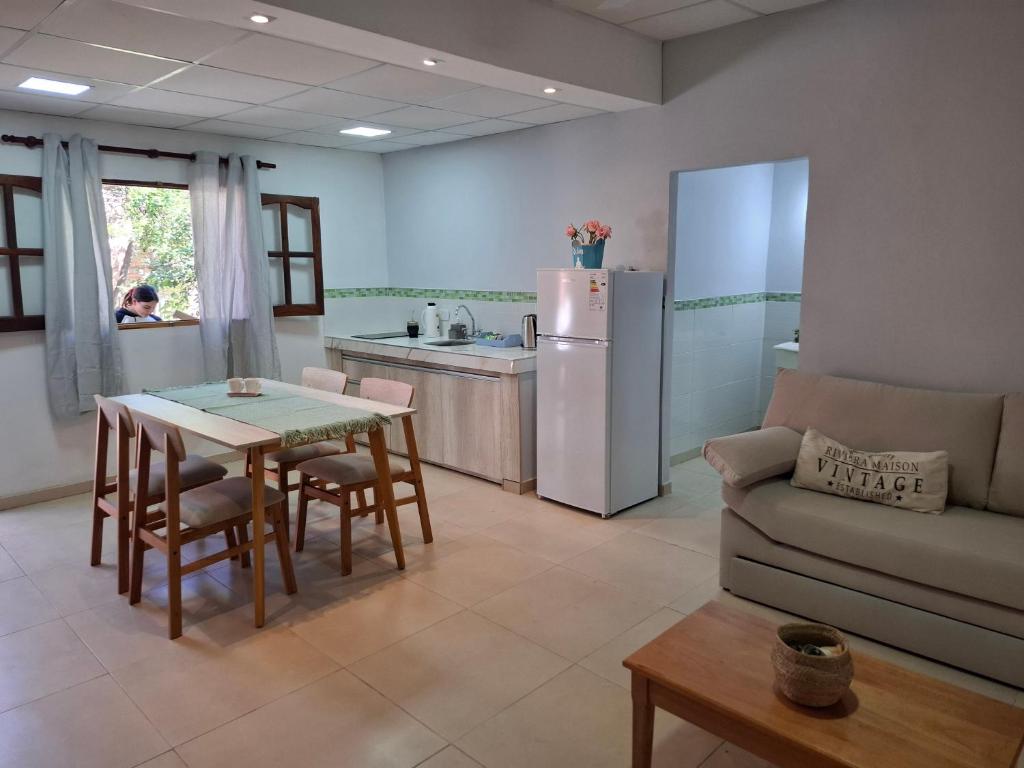 a kitchen and living room with a table and a refrigerator at Complejo Los Azahares in Presidencia Roque Sáenz Peña