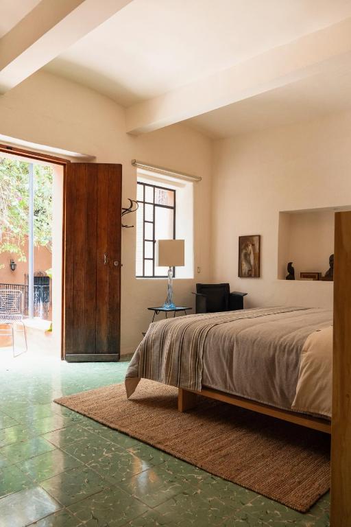 a bedroom with a bed and a living room at Casa Arrona Oaxaca in Oaxaca City