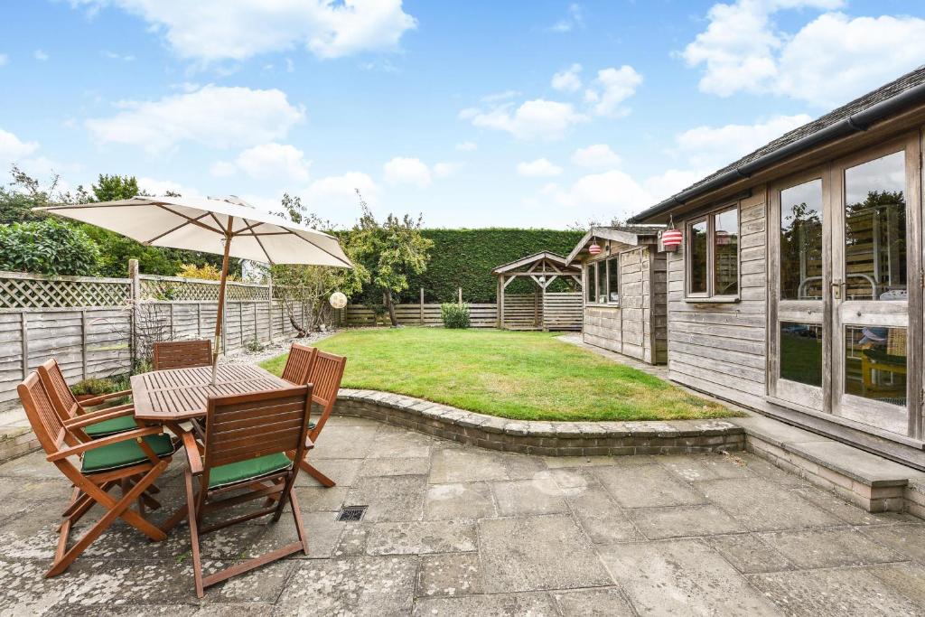 a patio with an umbrella and a table and chairs at Seasalt, West Wittering in West Wittering